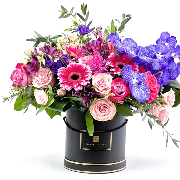 Bouquet of pink and purple flowers in a black hat box