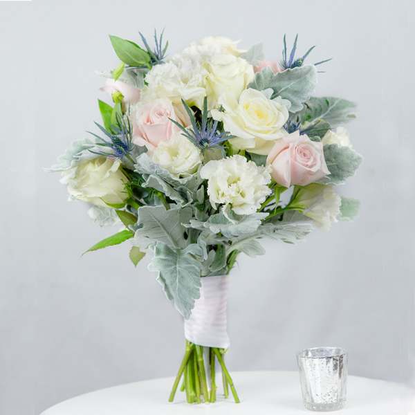 Bouquet of pale roses and white carnations with silvery foliage