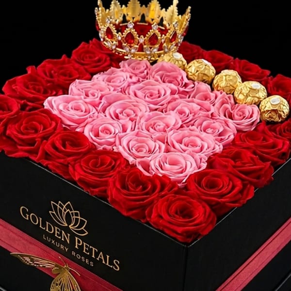 Heart-shaped rose box with pink and red roses, gold chocolates, and a crown