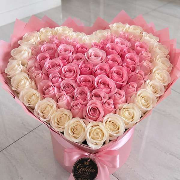Heart-shaped bouquet of pink and cream roses in a pink box
