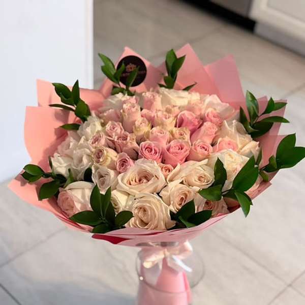 Bouquet of pink and white roses wrapped in pink paper