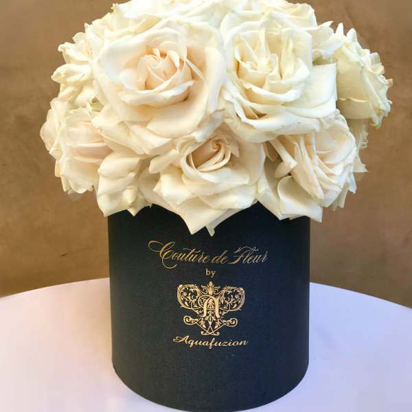 White roses arranged in a black cylindrical box