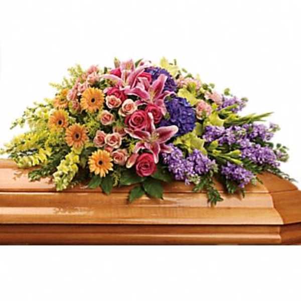 Colorful floral spray arranged on a wooden casket