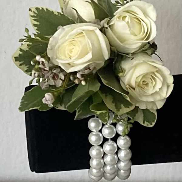 White rose corsage with pearl strands on a black wristlet