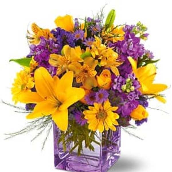 Yellow and purple mixed bouquet in a purple glass vase