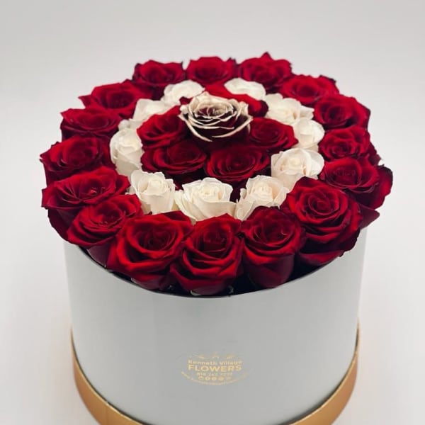 Red and white roses arranged in a round hat box