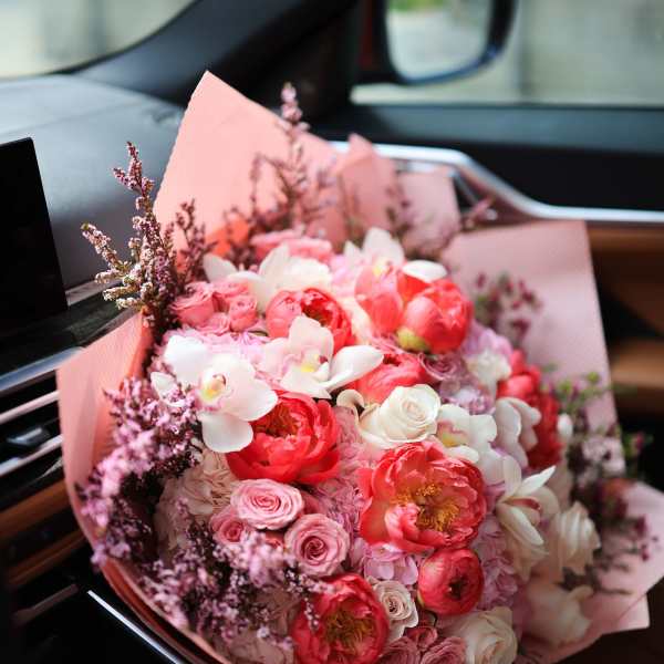 Pink and white bouquet with roses and peonies wrapped in pink paper