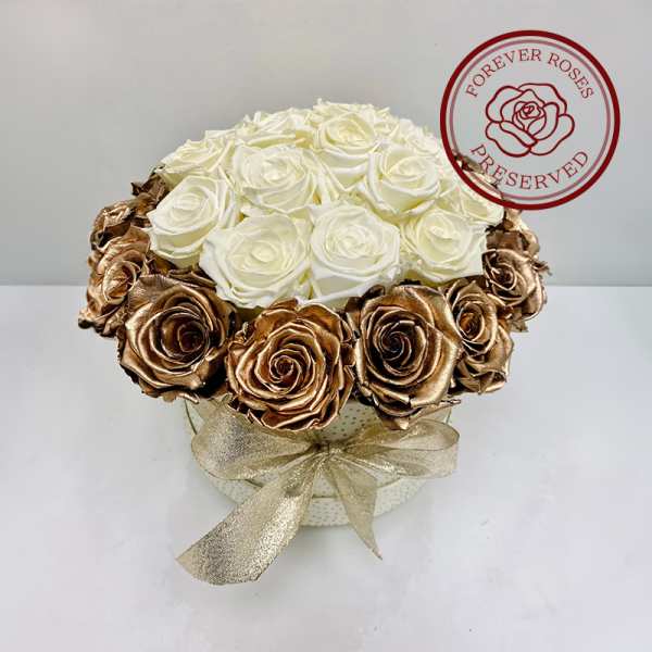 White and gold roses arranged in a round box with a ribbon