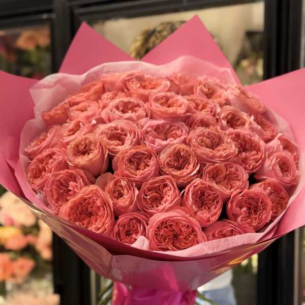 Large bouquet of pink roses wrapped in bright pink paper