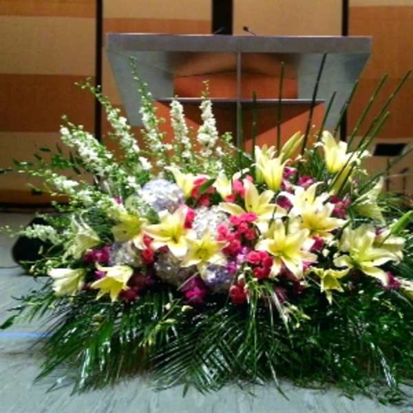Large floral arrangement with yellow lilies and pink flowers