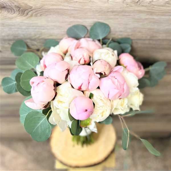 Bouquet of pink and white peonies with round eucalyptus leaves