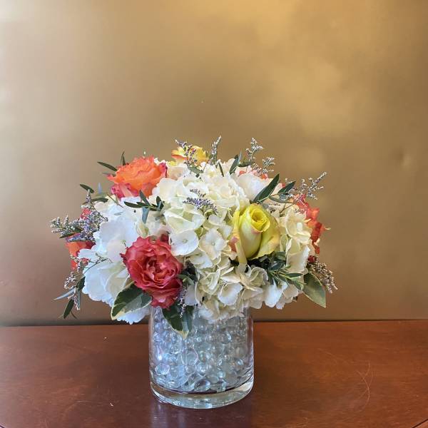 Mixed bouquet of white and coral flowers in a glass vase