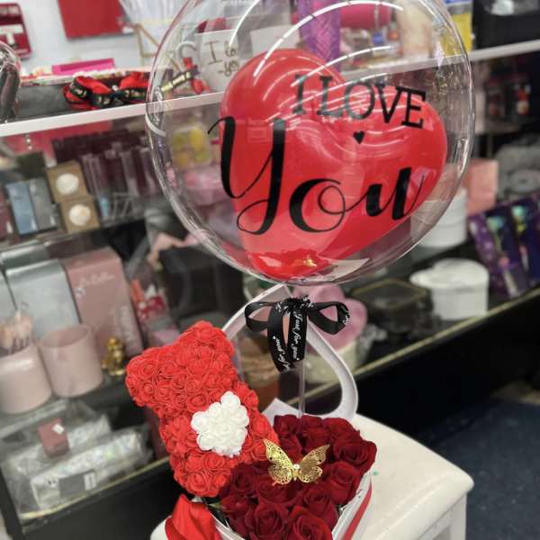 Heart-shaped rose arrangement with a clear balloon reading I Love You