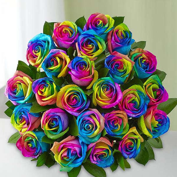 Bouquet of rainbow-colored roses with green leaves