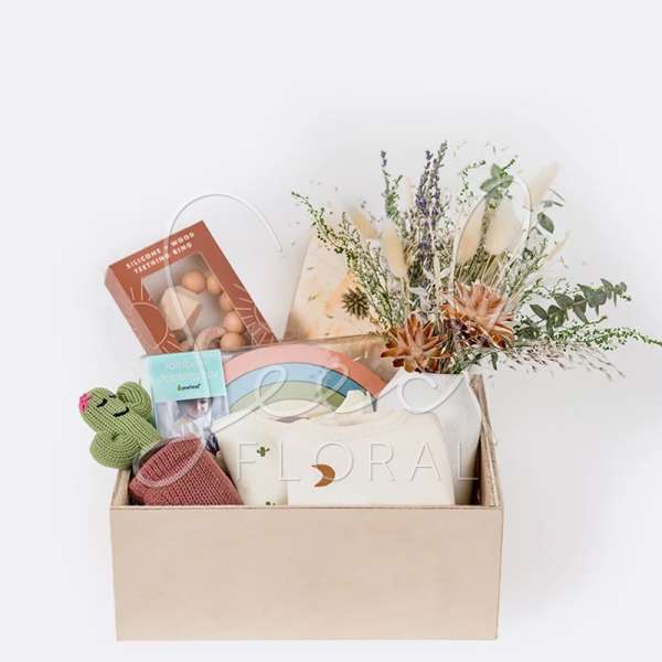 Gift box with dried flowers, baby items, and a cactus plush toy