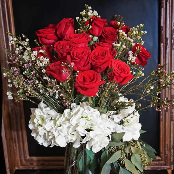 Red roses and white hydrangeas in a glass vase