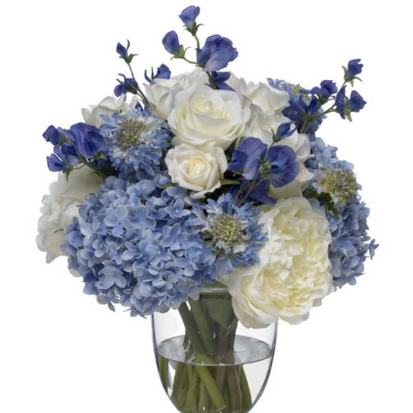 Blue and white flower arrangement in a clear glass vase
