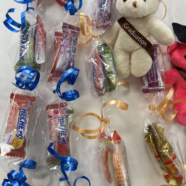Graduation teddy bear with wrapped candy bars and curled ribbons