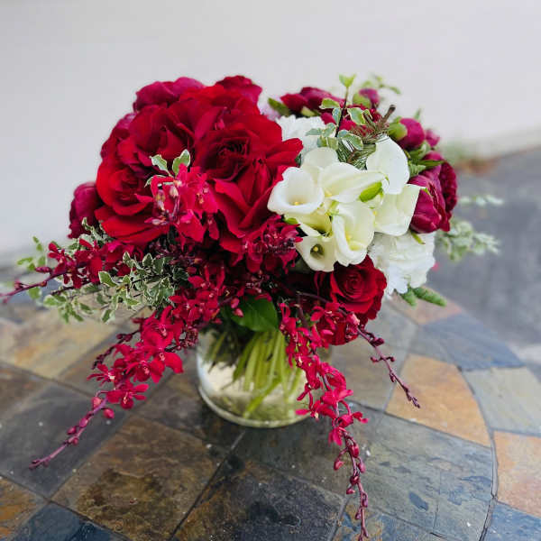 Red roses and white calla lilies in a glass vase