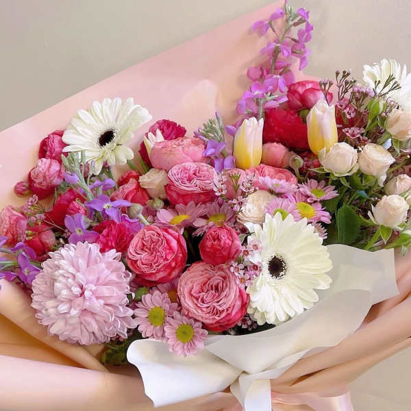Pink and white mixed bouquet with gerbera daisies and roses wrapped in pastel paper