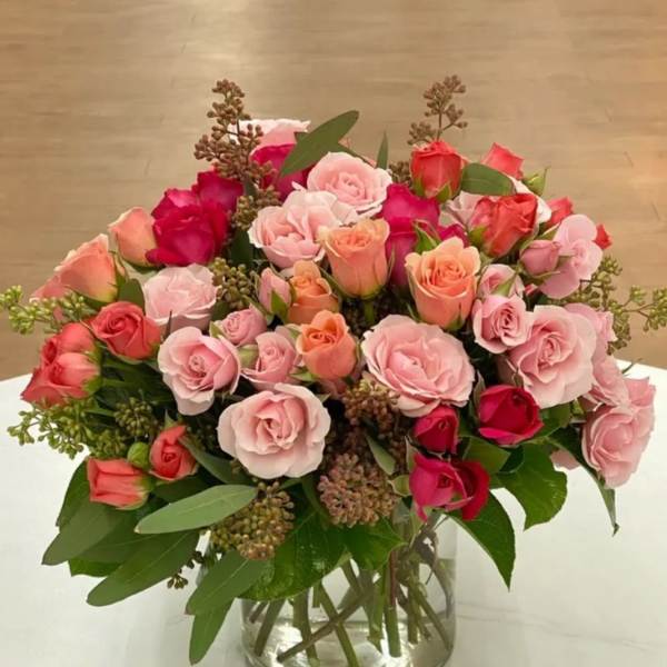 Bouquet of pink and coral roses in a clear glass vase