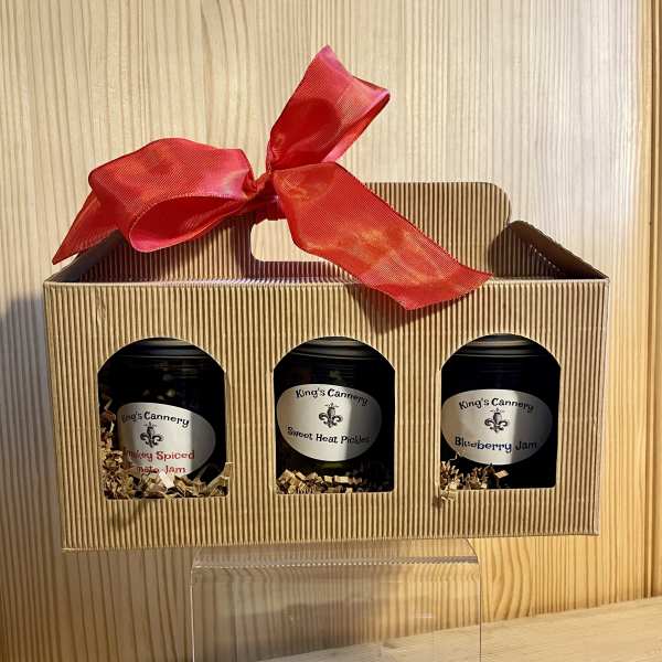 Gift box with three jars and a red ribbon bow