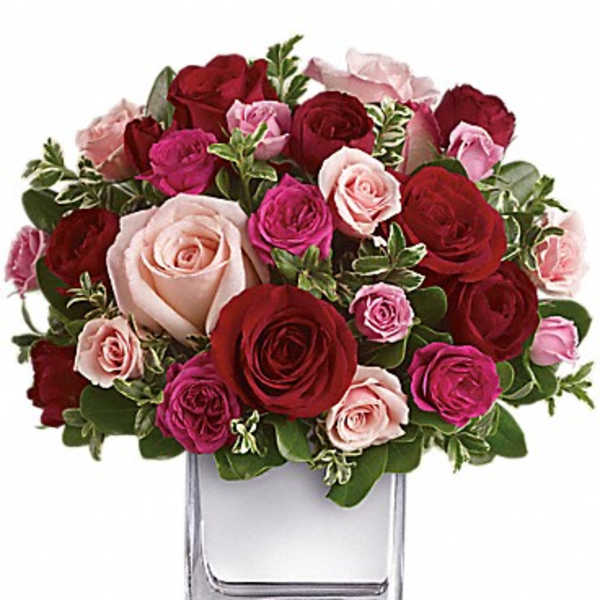 Bouquet of red and pink roses in a clear glass vase