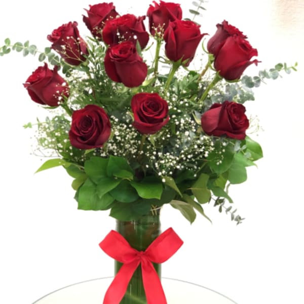 Red roses in a glass vase with a red ribbon