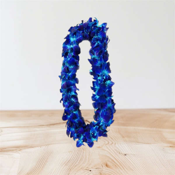 Blue floral lei on a light wood surface