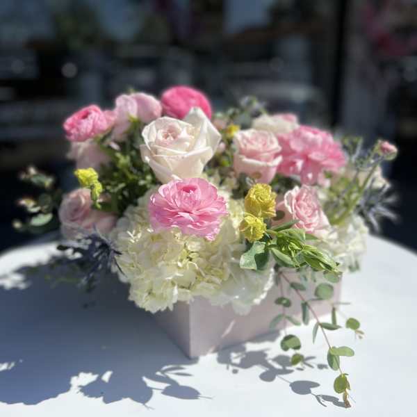 Pink and white roses with hydrangeas in a pale pink box