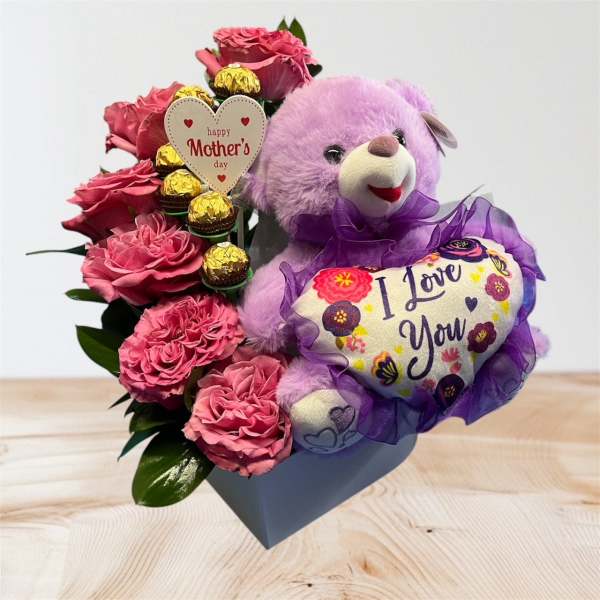 Pink roses with a purple teddy bear and chocolates in a gift box