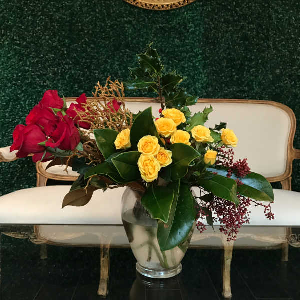 Red and yellow roses arranged in a clear glass vase