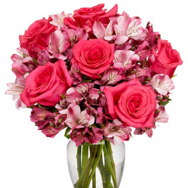 Pink roses and alstroemeria arranged in a clear glass vase