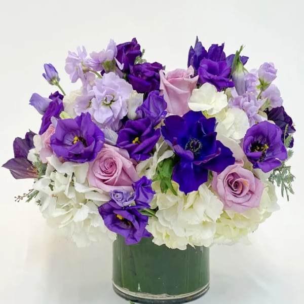Purple and white bouquet in a glass vase