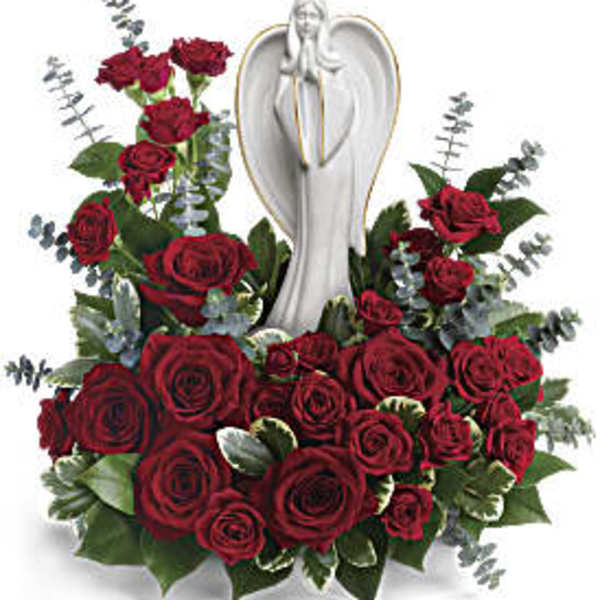 Red rose arrangement with eucalyptus surrounding a white ceramic angel figurine