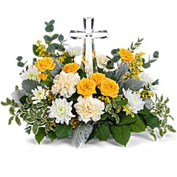 Low yellow and white flower arrangement with a clear crystal cross in the center.