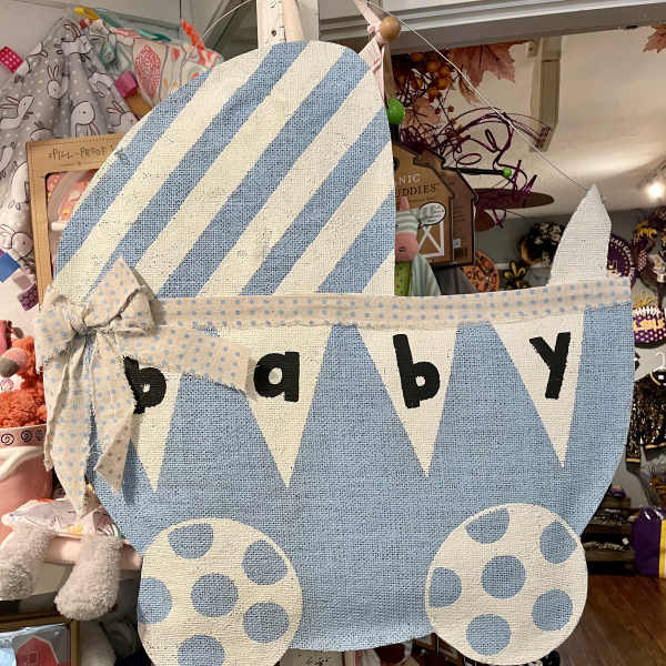 Blue and white fabric baby carriage wall hanging with the word baby