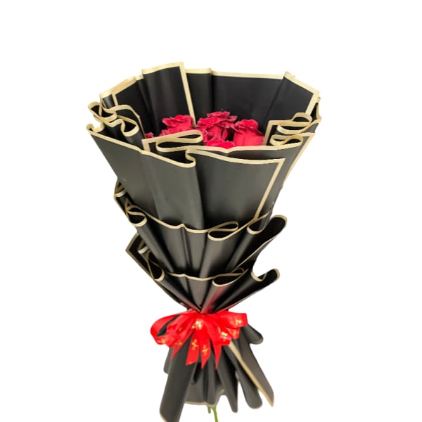 Bouquet of red roses wrapped in black paper with gold trim