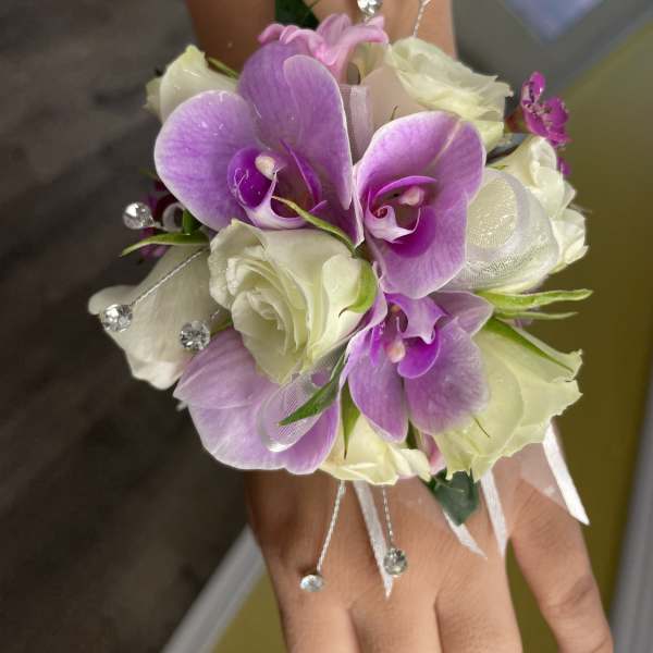 Purple orchid corsage with white roses on a wrist