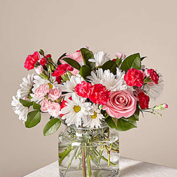 Pink roses and carnations with white daisies in a glass vase