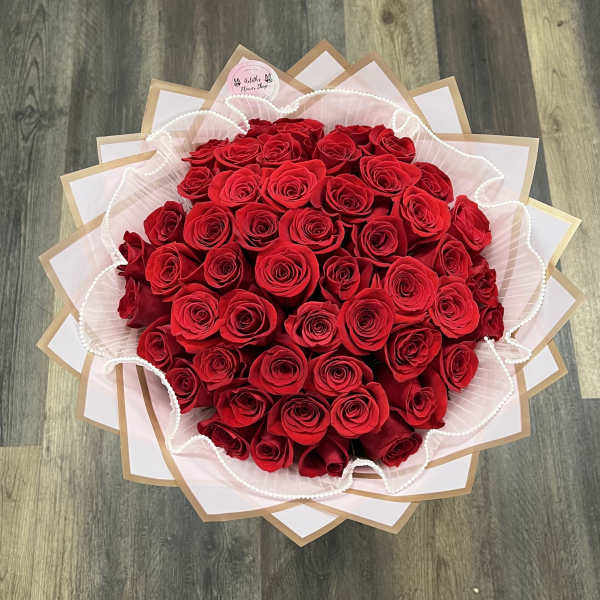 Large bouquet of red roses wrapped in pink and white paper