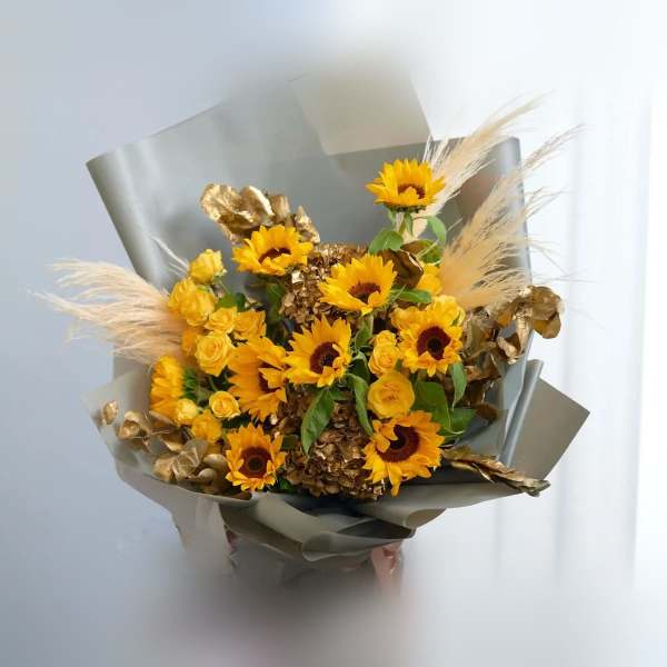 Bouquet of yellow sunflowers and roses with gold accents