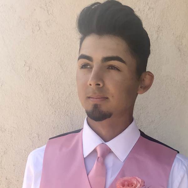 Man wearing a pink vest with a pink boutonniere