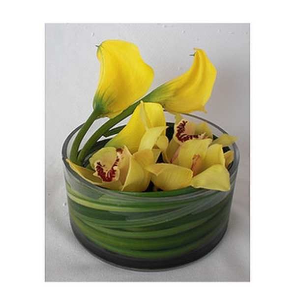 Yellow orchids arranged in a striped glass bowl