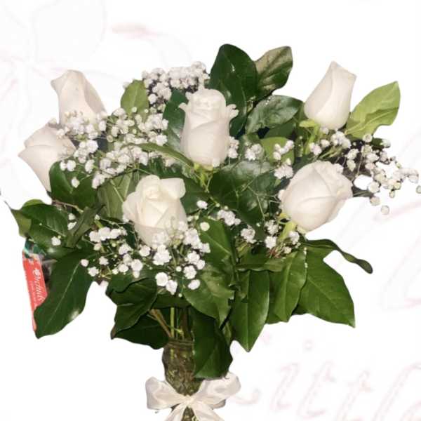 White roses and baby's breath in a glass vase with a ribbon