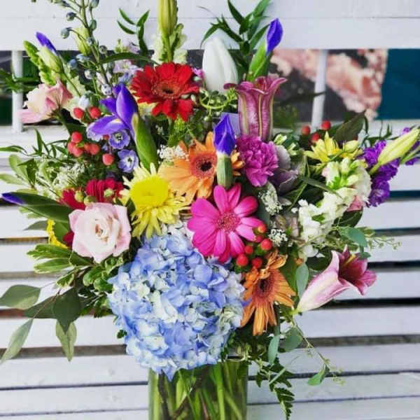 Colorful mixed bouquet in a glass vase with hydrangea and gerbera daisies