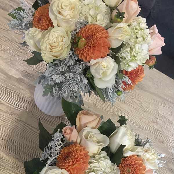Two floral bouquets with cream roses, orange blooms, and white hydrangeas