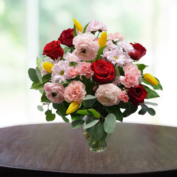 Bouquet of red and pink flowers in a clear glass vase