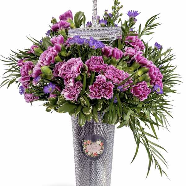 Purple carnations and daisies in a tall silver vase