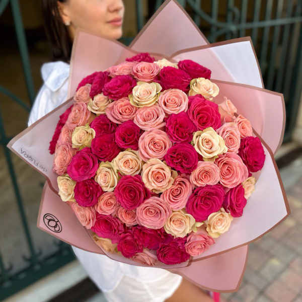 Large bouquet of pink and cream roses wrapped in pink paper